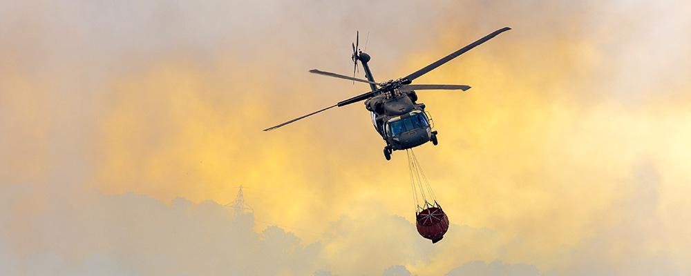Helicopter carrying water to fire