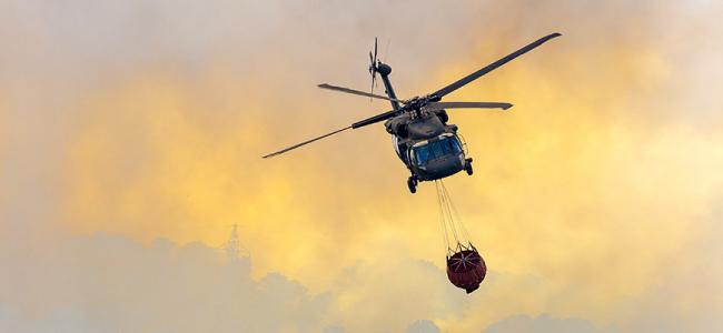 Helicopter carrying water to fire